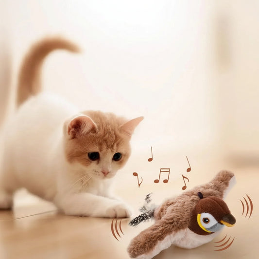 Chaton roux jouant avec un oiseau interactif en peluche — jouet pour chat avec ailes mobiles et chant authentique